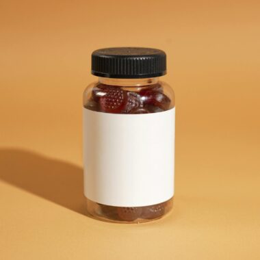 A clear bottle filled with gummy vitamins on an orange background, ideal for health and wellness themes.