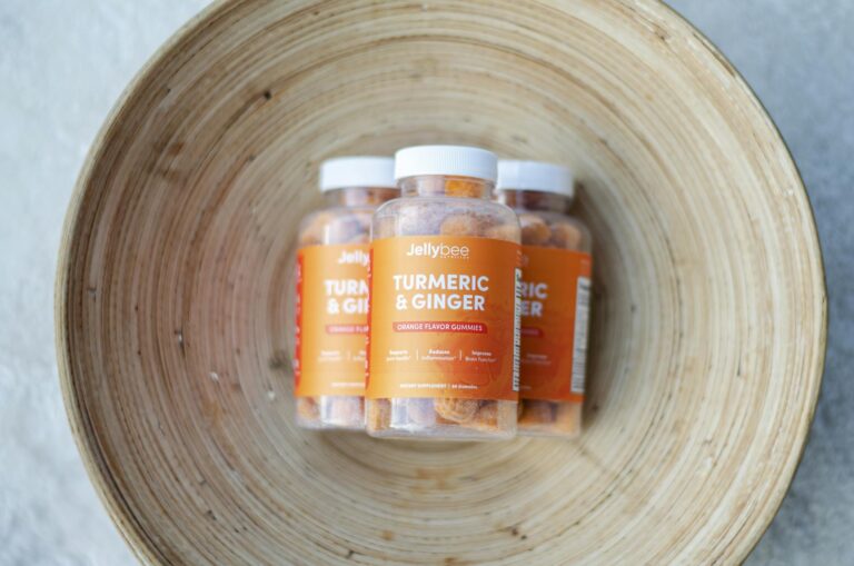 Close-up of Jellybee Turmeric & Ginger orange flavor gummies in a wooden bowl.